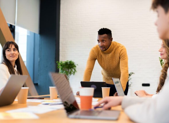 Black male team leader at business meeting in an office